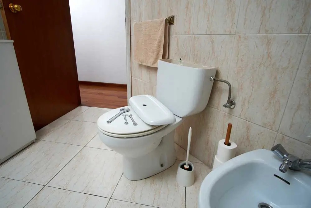 Licensed plumber repairing toilet system in Brisbane home